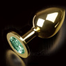 Большая золотая анальная пробка с закругленным кончиком и изумрудным кристаллом - 9 см. купить в секс шопе