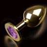 Большая золотая анальная пробка с закругленным кончиком и фиолетовым кристаллом - 9 см. купить в секс шопе