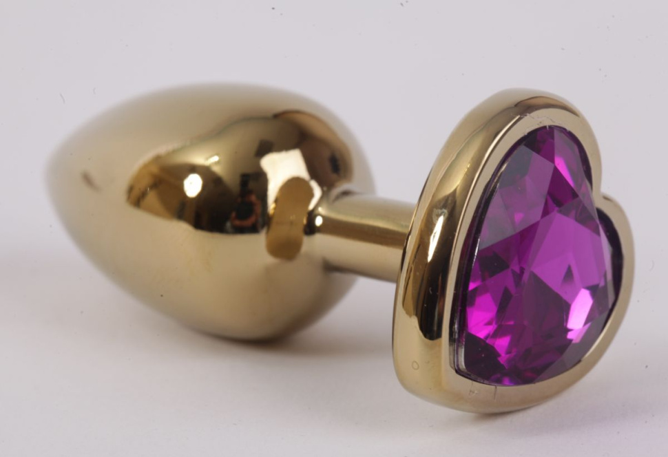 Золотистая анальная пробка с фиолетовым стразиком-сердечком - 7,5 см. купить в секс шопе