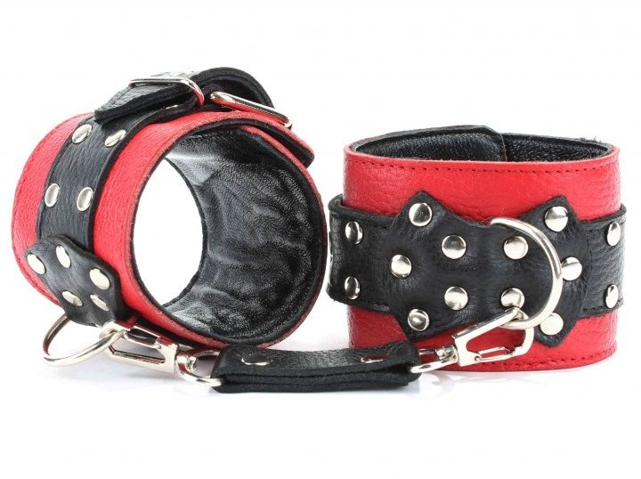 Красные наручники с чёрными проклёпанными ремешками с пряжкой  купить в секс шопе