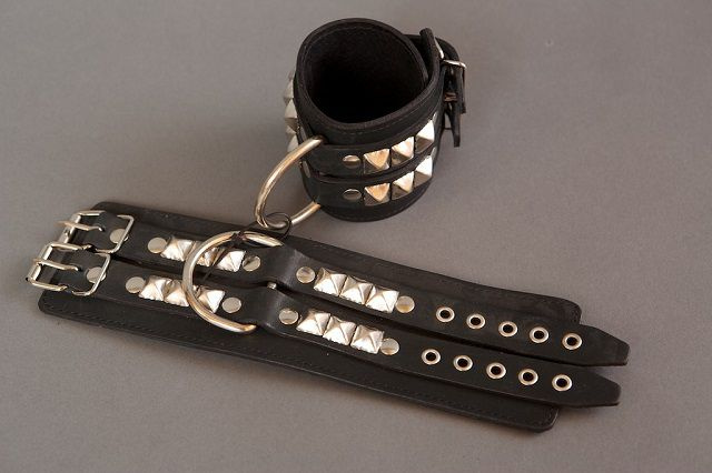Широкие чёрные наручники с квадропуклями купить в секс шопе