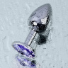 Серебристая конусовидная анальная пробка с фиолетовым кристаллом - 7 см.  купить в секс шопе