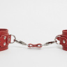 Красные кожаные наручники с соединительным ремешком купить в секс шопе